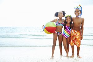 three kids playing at the beach