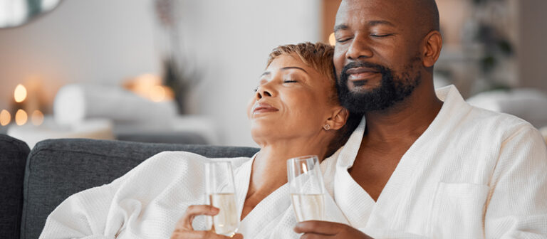 Couple relaxing in robes drinking champagne
