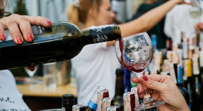 people pouring a glass of wine